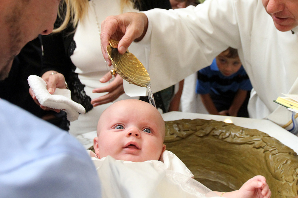 A baby is seen during her baptism. France's Catholic bishops criticized legislation to allow medically assisted procreation for single mothers and lesbian couples and urged citizens to help block its enactment. (CNS photo/Gregory A. Shemitz) See FRANCE-PROCREATION Sept. 23, 2019.